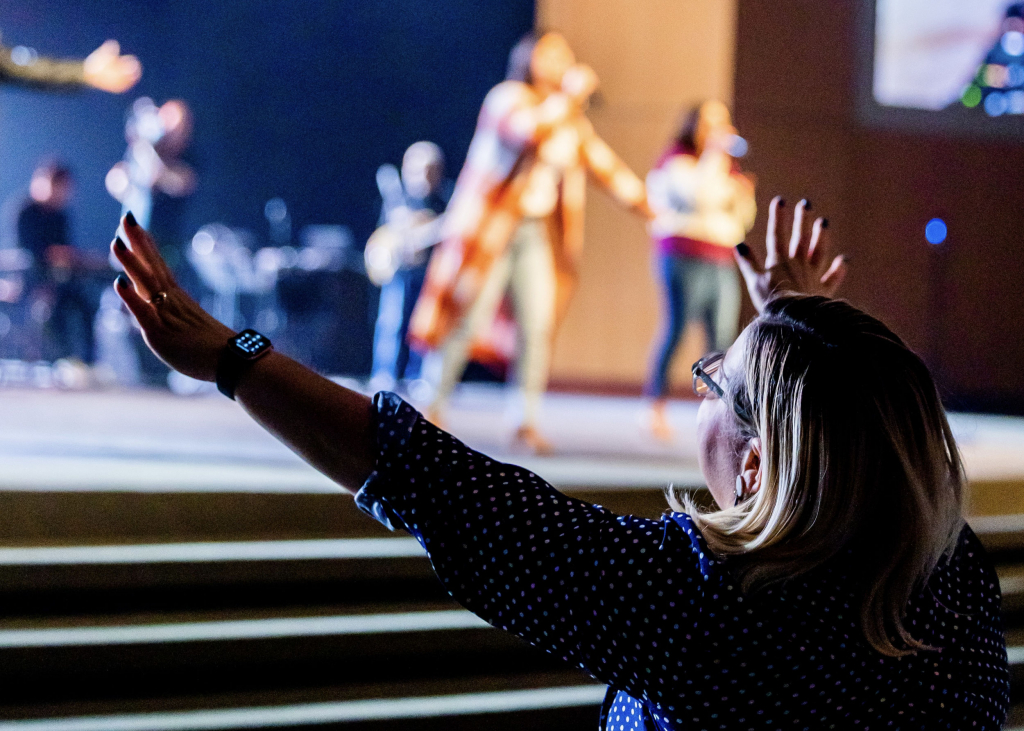 Leading Worship with Compassion | Worshipper with hands raised at a church worship service or other worship event.